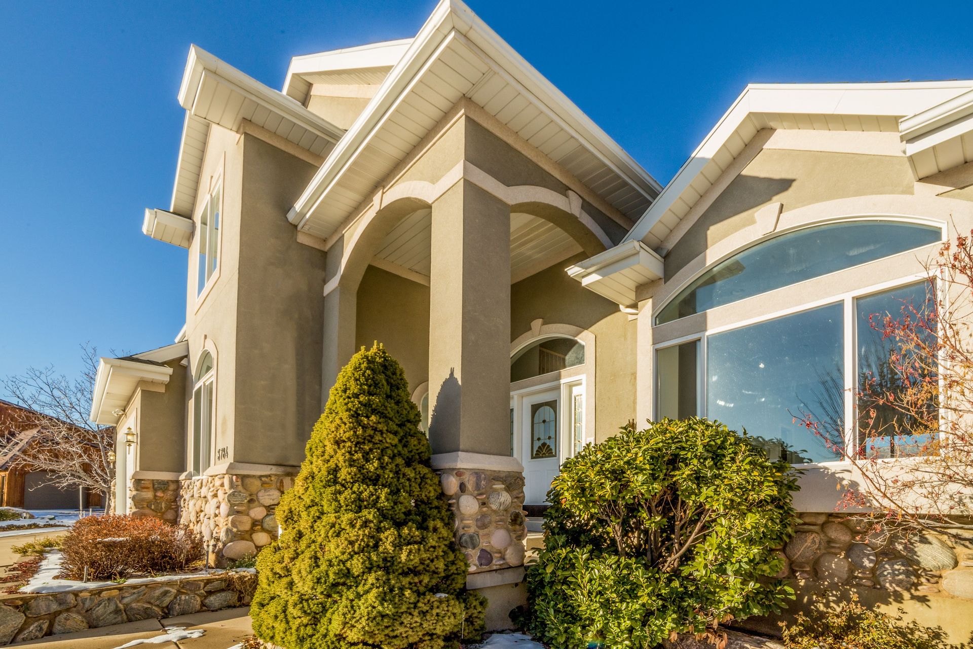Bright and elegant exterior view of a modern suburban house with landscaped front yard.